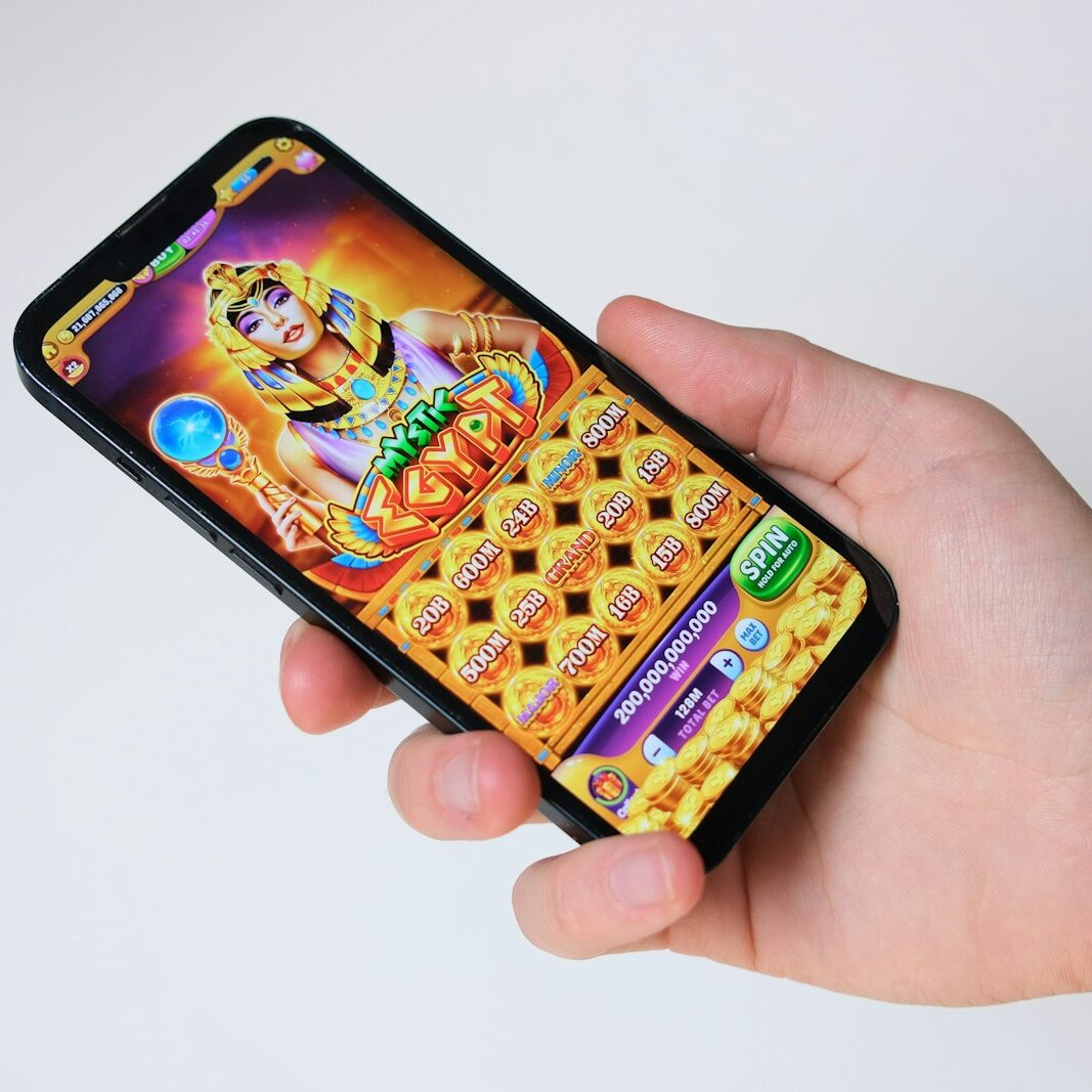 A hand holds a phone with an egyptian-themed game.